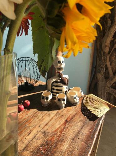 a table with skulls and a vase with a flower at Hotel Sal de Mar in San Agustinillo