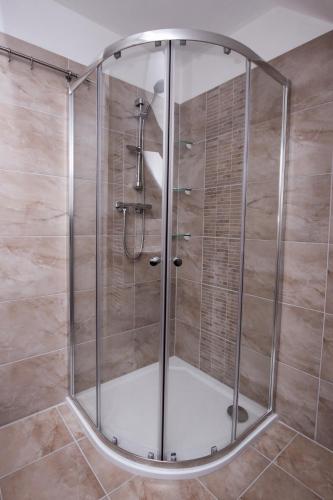a shower with a glass enclosure in a bathroom at Chalupa Kadov in Sněžné