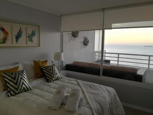 1 dormitorio con 1 cama grande y vistas al océano en CPM Apartment, en Viña del Mar