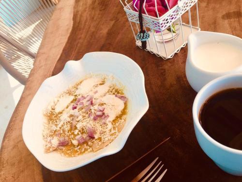a bowl of food on a table next to a cup of coffee at Hotel Sal de Mar in San Agustinillo