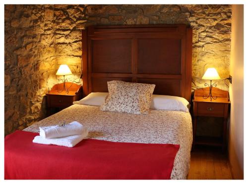 een slaapkamer met een groot bed met 2 lampen bij Casa L´Andorvio in Leiguarda