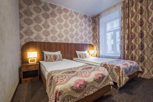 ein Hotelzimmer mit 2 Betten und einem Fenster in der Unterkunft Blues in Sankt Petersburg