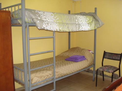 a bunk bed room with two bunk beds and a chair at Finca La Virreinita in Panaholma