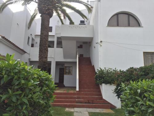 a palm tree in front of a white building at Apartamento Santos-Meerblick-Olhao-Algarve in Olhão