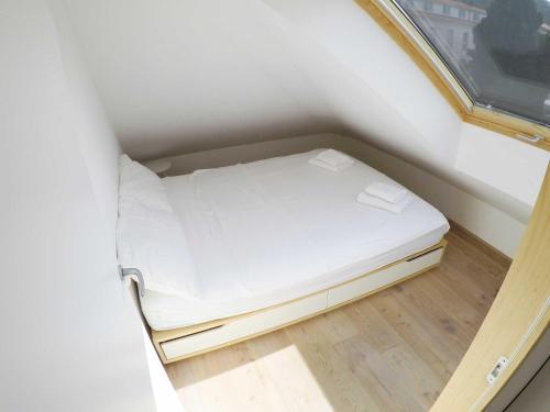 ein kleines Bett in einem kleinen Zimmer mit Fenster in der Unterkunft Hvar attic modern design - town center with a great view in Hvar