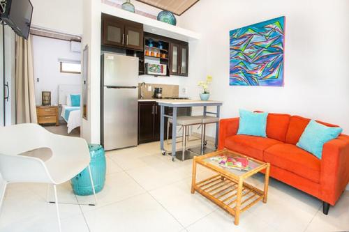 a living room with a red couch and a table at Tico Tico Villas - Adult Only in Manuel Antonio
