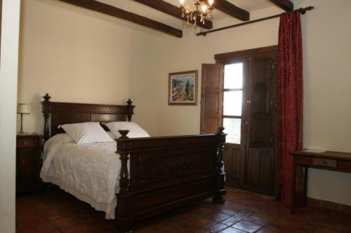 a bedroom with a wooden bed and a window at Casa Rural Rincón de la Fuente in Buenaventura