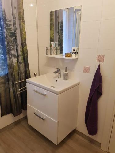 a white bathroom with a sink and a mirror at Lille Villa Severin in Mosterhamn