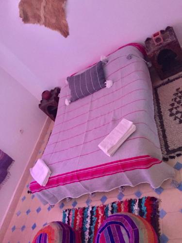 a bedroom with a bed with pink sheets and pillows at tamazirt surf house in Taghazout
