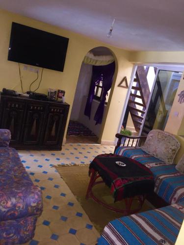 a living room with a couch and a flat screen tv at tamazirt surf house in Taghazout