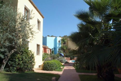 a courtyard of a building with a palm tree at Borgo Degli Ulivi in Àrbatax