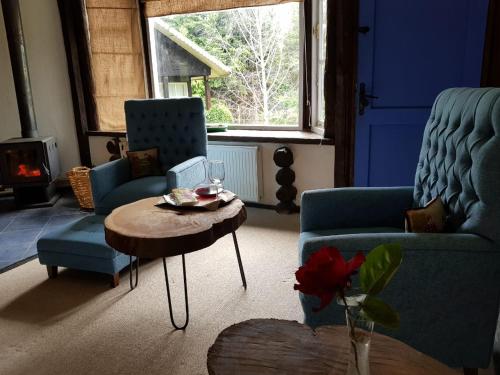 a living room with two blue chairs and a table at The Patagonian Lodge in Coihaique