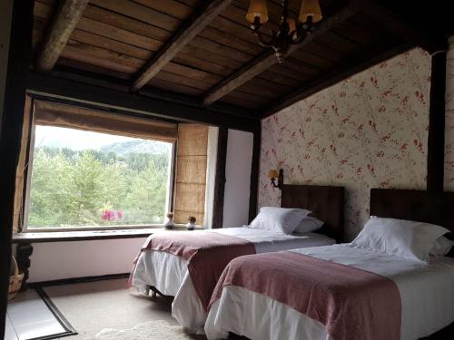 a bedroom with two beds and a large window at The Patagonian Lodge in Coihaique
