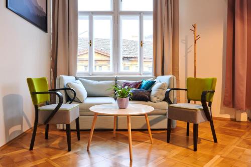 プラハにあるRoyal Route Residence Lesser Townのリビングルーム(ソファ、テーブル、椅子付)