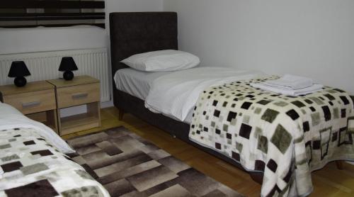 a bedroom with two beds and two night stands at Apartmani Marić in Novi Pazar