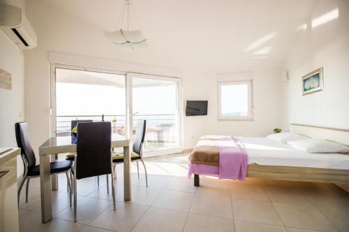 a bedroom with a bed and a table and chairs at Apartment Milka 1 in Njivice