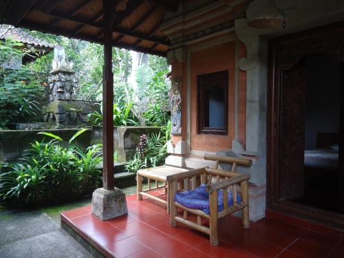un banco en el porche de una casa en Pondok Kecil Bungalow, en Ubud