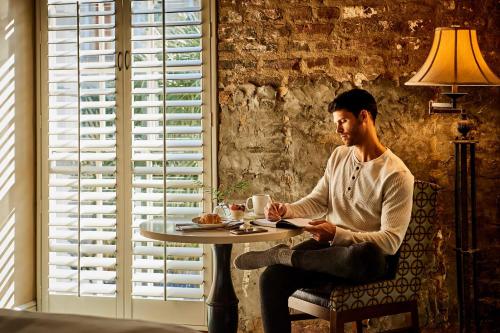 a man sitting at a table in front of a window at Harbourview Inn in Charleston
