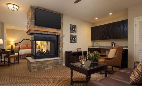 a living room with a fireplace with a flat screen tv at Casa Munras Garden Hotel & Spa in Monterey