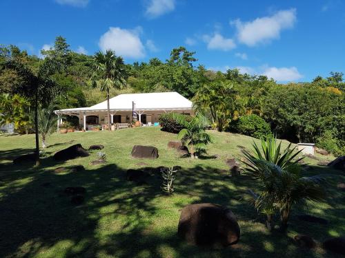 a house in a field with rocks and trees at L'Ecrin Vert in La Trinité