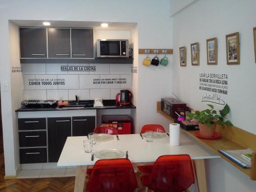 a small kitchen with a table and red chairs at Petit Maipu in Buenos Aires