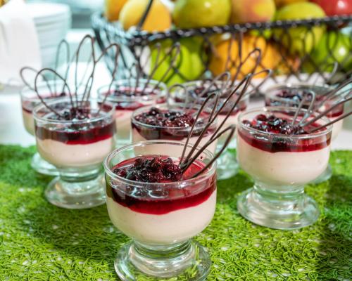 a row of glasses of dessert with cherries in them at Biohotel Organic Suites in Bogotá