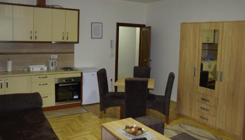 a kitchen and living room with a table and chairs at Apartmani Marić in Novi Pazar