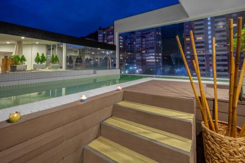 a building with stairs and a swimming pool at night at Biohotel Organic Suites in Bogotá