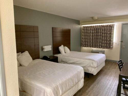 a hotel room with two beds and a window at Dallas Love Field Inn in Dallas