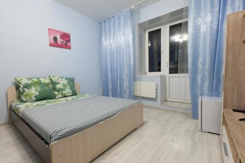 モスクワにあるArtemRoomのベッドルーム1室(青いカーテン、窓付)