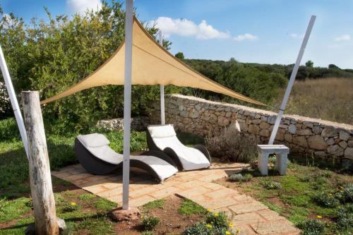 a couple of white chairs under a tent at Le Gioie - Villa Macchia Mediterranea - Splendida villa vista mare immersa nel verde in Torre Pali 