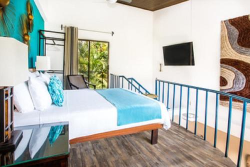 a bedroom with a bed and a balcony at Tico Tico Villas - Adult Only in Manuel Antonio