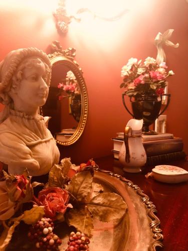 a table with a statue of a bust and a mirror at Princess Anne Book Lovers Inn in Princess Anne