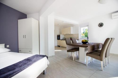 a bedroom with a bed and a table and chairs at Colic in Njivice