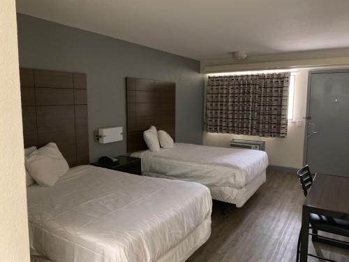 a hotel room with two beds and a window at Dallas Love Field Inn in Dallas