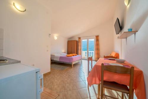a room with a bed and a table with chairs at Apartments Slavica in Luka