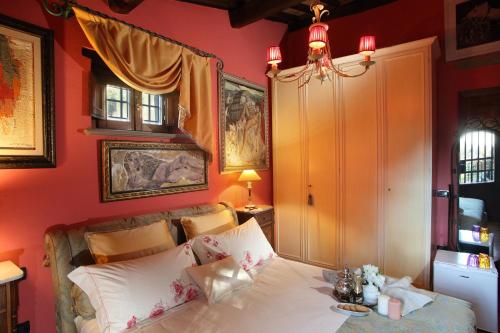 a bedroom with a bed with red walls at Camera Rosa in Borgo a Buggiano