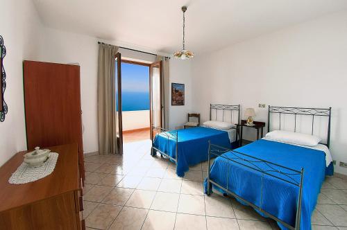 two beds in a room with a view of the ocean at Casa Nancy in Amalfi
