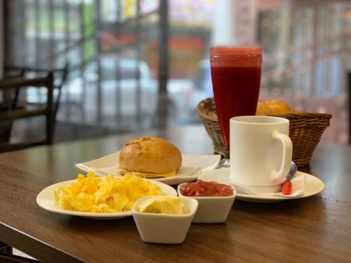 - une table avec deux assiettes de nourriture pour le petit-déjeuner et une boisson dans l'établissement San Rafael Hotel, à Guaranda