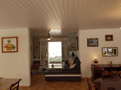 a living room with a couch and a table at L'Ecrin Vert in La Trinité