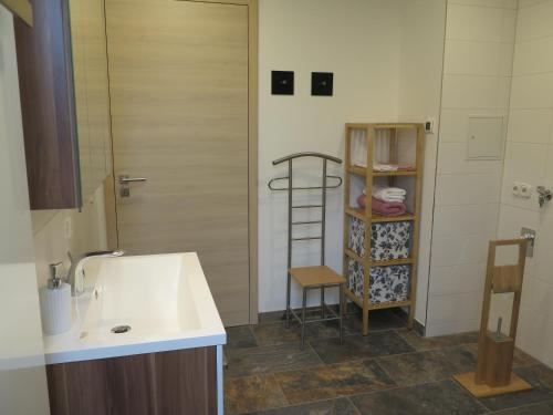 a bathroom with a sink and a shelf with towels at CrossARTig in Zwickau