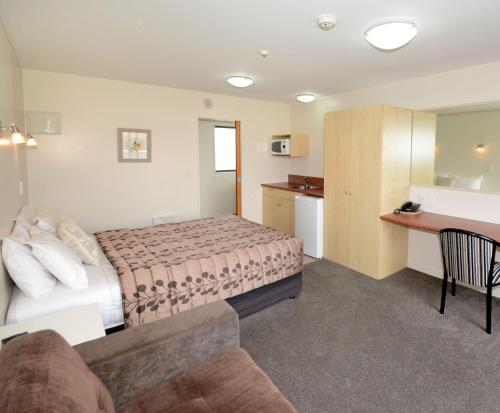 a hotel room with a bed and a desk at Bella Vista Motel Mosgiel in Mosgiel