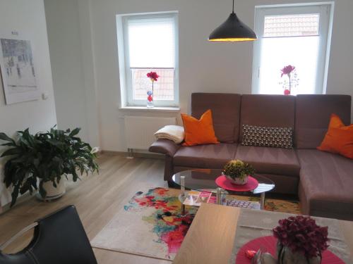 a living room with a brown couch and orange pillows at CrossARTig in Zwickau