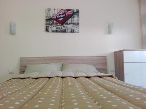 1 cama en un dormitorio con un cartel en la pared en ApartPool El Torreón, en Adeje