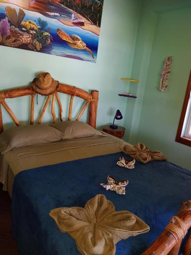 a bedroom with a bed with a blue comforter at Slo-N-Ez Villa Terrace (Ocean View) in Caye Caulker