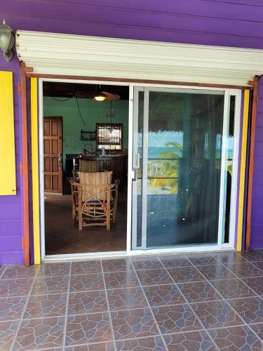 a purple house with a sliding glass door at Slo-N-Ez Villa Terrace (Ocean View) in Caye Caulker