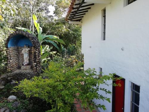 a statue in front of a building next to a building at Hotel Casona Las Juanas in San José de Pare