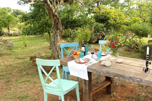 a wooden table with chairs and a bottle of wine at Finca San Pedro in Barichara