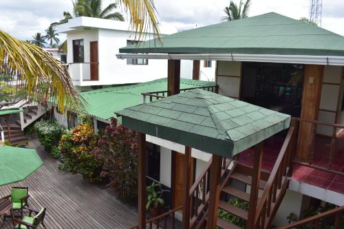 a balcony of a building with a green roof at Hotel San Vicente Galapagos in Puerto Villamil