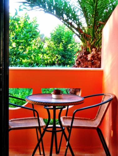 a small table and two chairs in front of a window at Chrissas Apartments in Rethymno